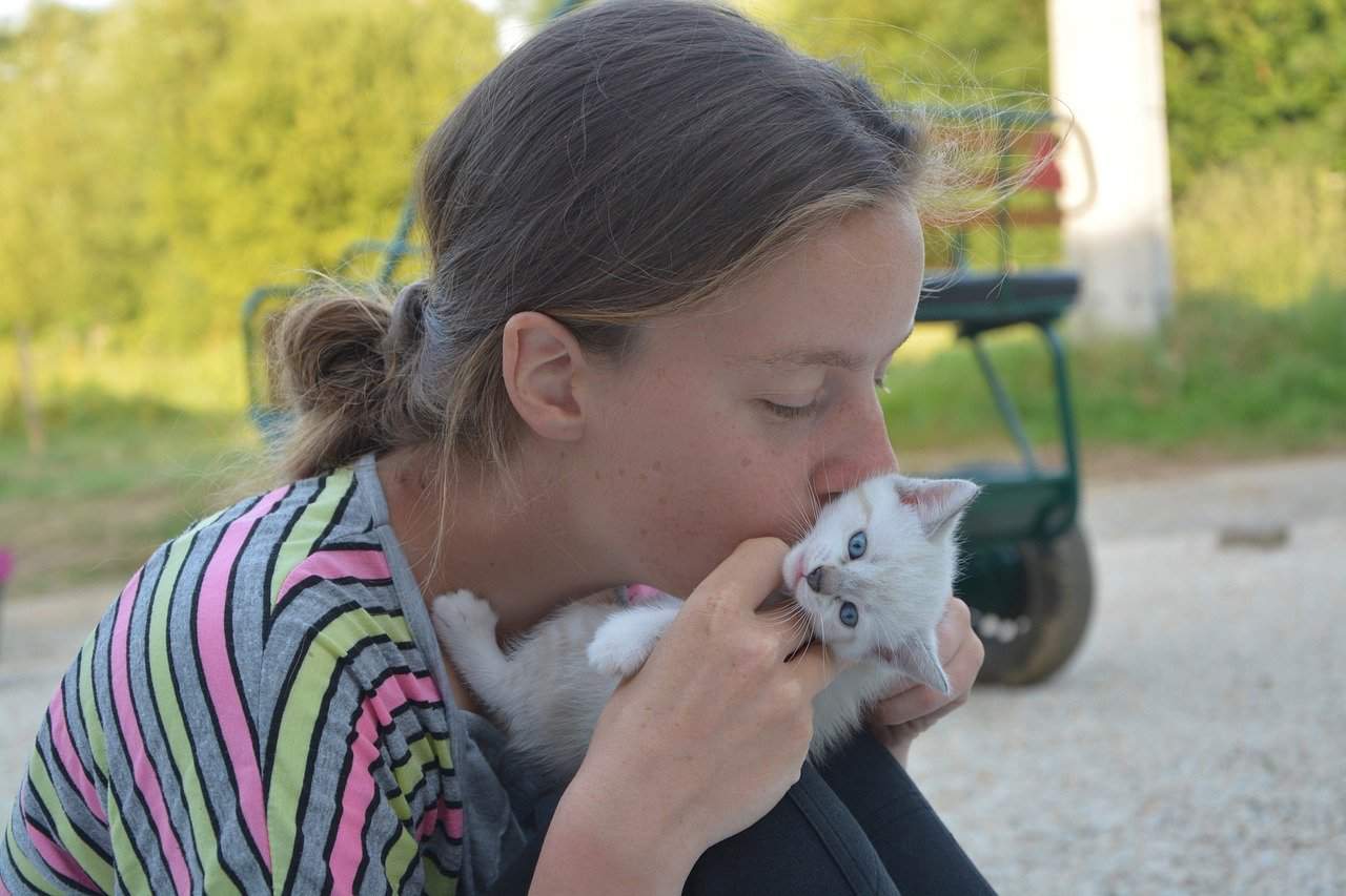 girl kissing a cat