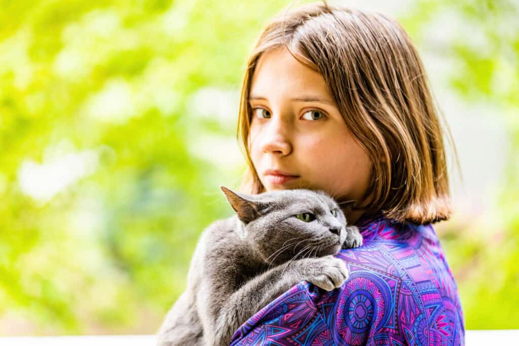 young girl with a russian blue cat