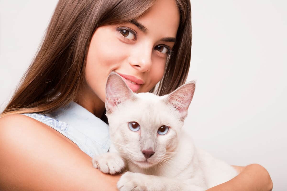 girl holding a siamese cat